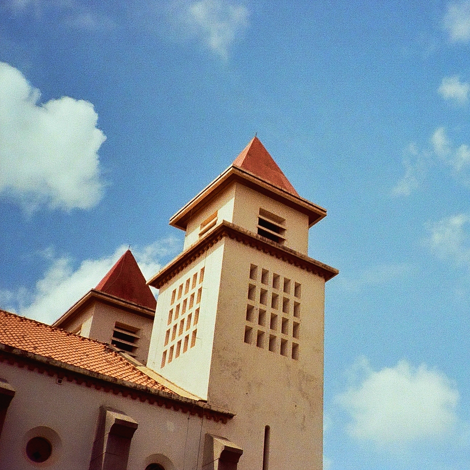 old portuguese colonial cathedral framed against a blue cloudy sky