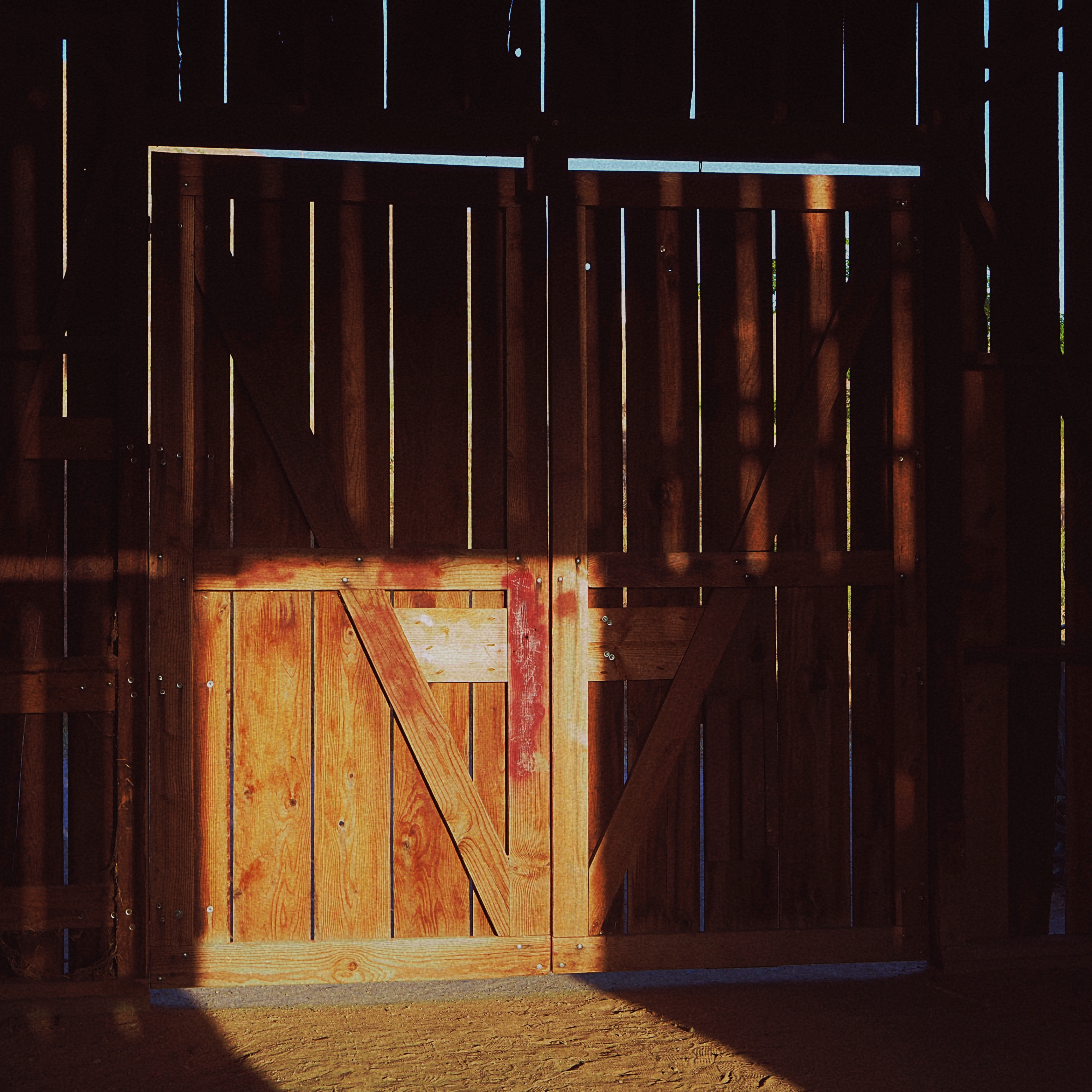 patch of light shining on the inside of an old barn door